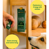 Person holding a package of Earth Rated pet bags with a dog looking on, near a wooden shelf.