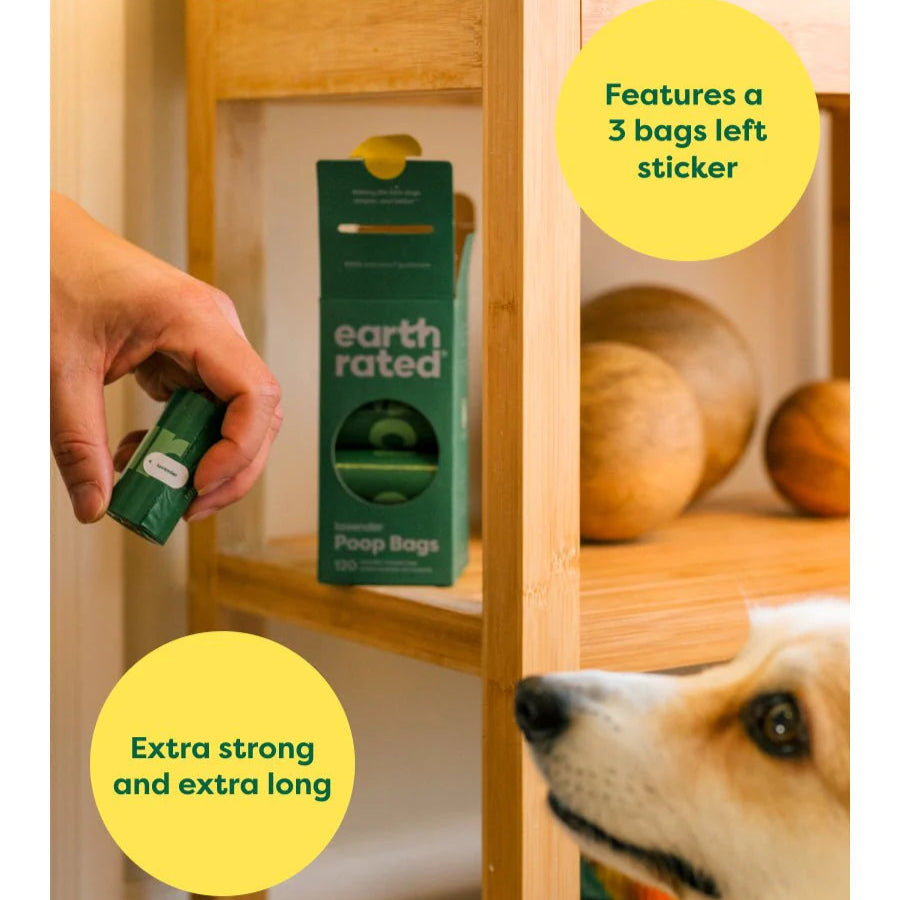 Person holding a package of Earth Rated pet bags with a dog looking on, near a wooden shelf.